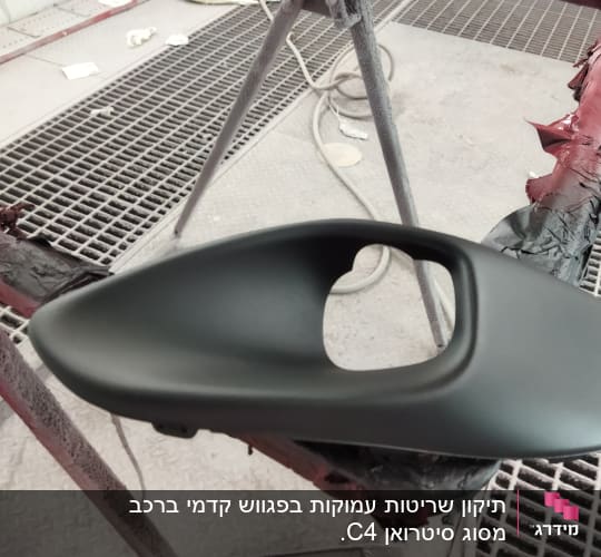 חלק רכב צבוע מונח על מתקן עבודה